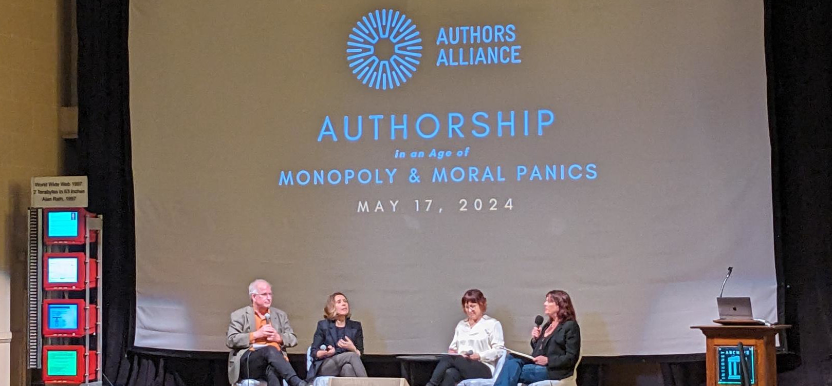 Panelists on stage at Authorship in an Age of Monopoly & Moral Panics